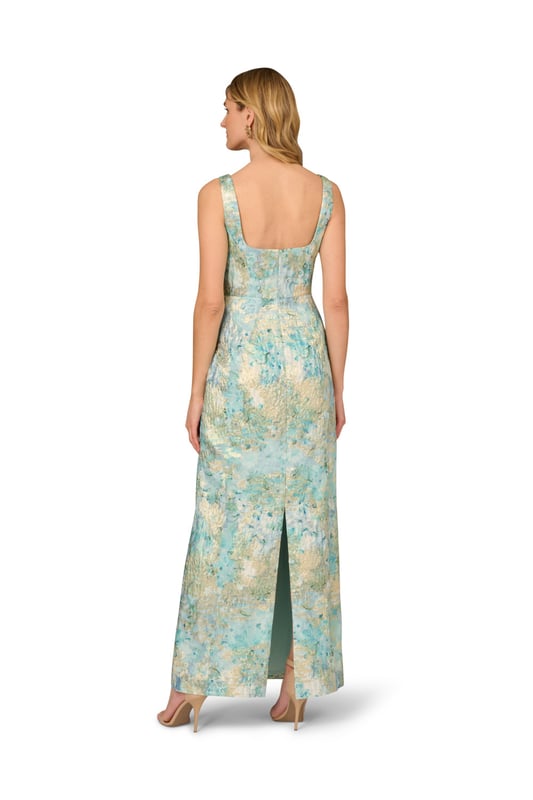 Fine fabrication and elegant details make this floral gown stand above the rest. This floral dress features a fitted bodice with square neckline and tank straps, a floor-skimming skirt with a slit at the back, and pleated details at the waist that shows off the figure. Crafted from woven metallic jacquard fabric source from Korea, this dress is decked out in beautiful floral print. A low back and hidden zipper closure are the final details that make this evening gown shine. Styled with nude heels and sparkling jewelery, this floral gown is perfect for a formal or black-tie event.