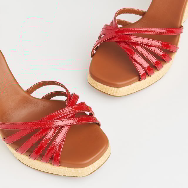 With a hint of Seventies' playfulness, our Solange wedges balance height and comfort. Crafted in Italy from red patent leather, they have a crossover multi-strap design, a delicate ankle strap and a beige raffia 110mm wedge sole. Perfect with summer's cool cotton and linen skirts and dresses, they're also great with wide leg trousers.