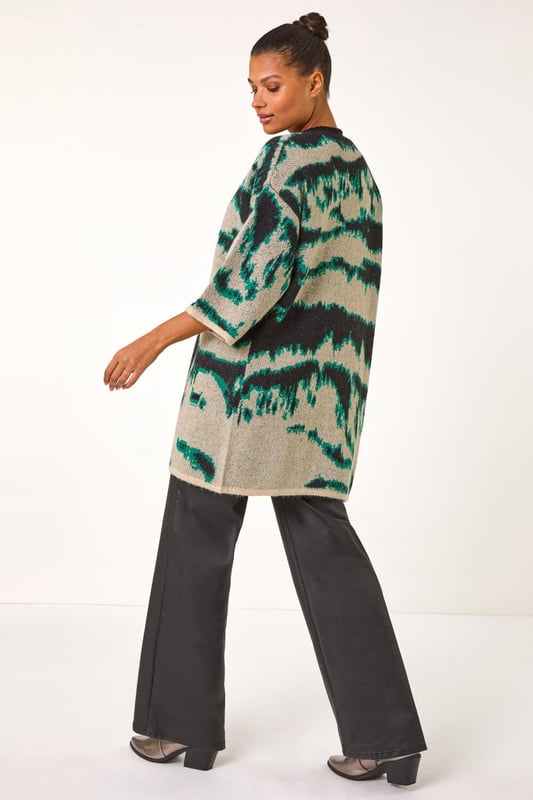 Abstract Print Knit Cover Up from Roman. Stay stylish and warm with this abstract knit cover up, perfect for the Autumn/Winter season. Designed with an eye catching abstract knit pattern, this cover up features an easy edge to edge front and chic short sleeves for a versatile look. Layer it over a long sleeve top and jeans for a fashionable and cosy outfit.