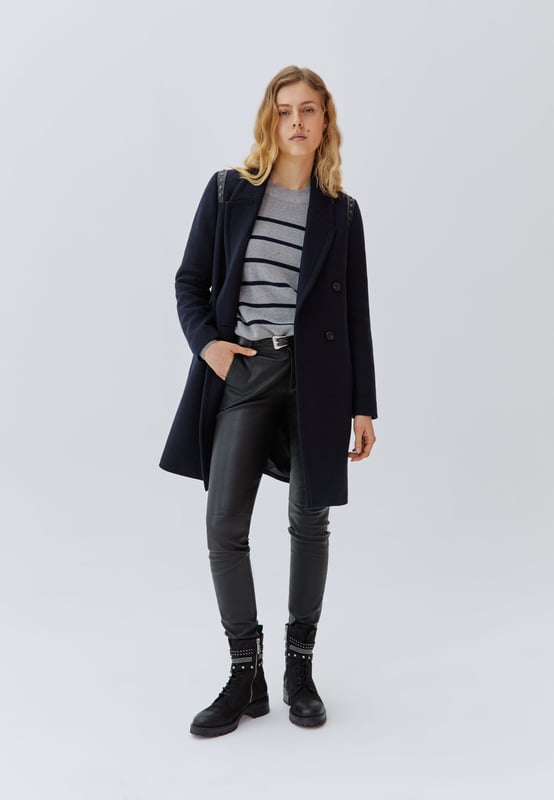 Women's navy coat in wool and polyamide. Sewn-in tailor collar, long sleeves. 2 side pockets, plain jacquard lining with skulls motif. Nails decoration on rock oppo on the shoulders. Crossed buttoning, front button closure. Straight cut, mid-thigh length.