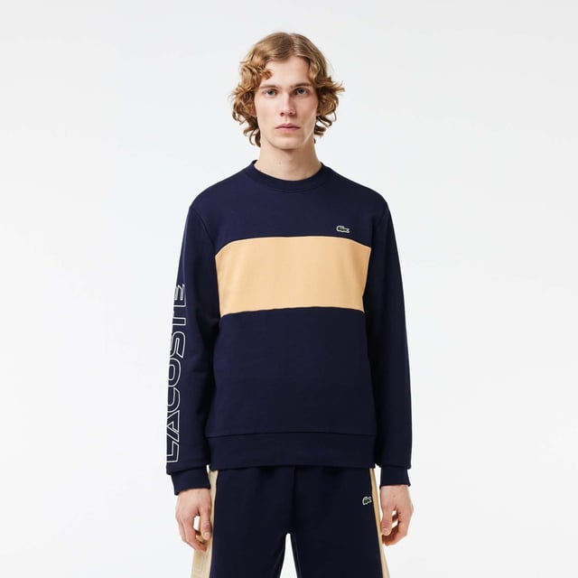 Color combination and graphics for a Lacoste dynamic and creative identity. Classic fit  natural ease on body with comfortable sleeves Our classic French terry Cut & sewn colorblock crew neck sweatshirt in mix of two different colors Rib at sleeves and bottom of body 3cm green crocodile at chest Lacoste wording 3D print at right sleeve.