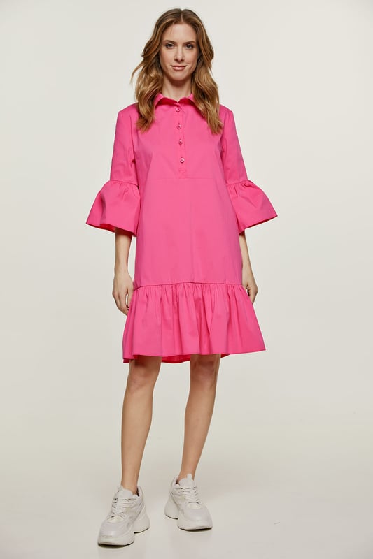 Deze fuchsia jurk is gemaakt van geweven stretch poplin. Het heeft klokkende mouwen van ¾ lengte. De jurk heeft een kraag en een sluiting in de taille met plastic knopen. Een naad onder de buste zorgt voor een perfecte pasvorm. De jurk heeft een brede zoom met ruches. De jurk heeft een losse pasvorm en valt boven de knie.