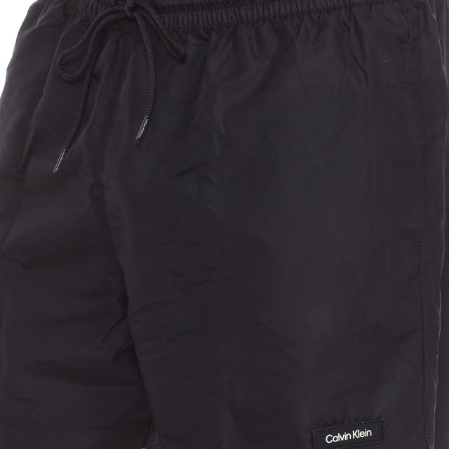 Este pack exclusivo de Calvin Klein incluye un bañador y una toalla, ideales para disfrutar de un día de playa o piscina con estilo y comodidad.

Bañador: Con un diseño clásico, el bañador presenta una cintura elástica con cordón ajustable para un ajuste perfecto y cómodo. El logo de la marca está discretamente ubicado en la pierna inferior, añadiendo un toque distintivo. 

Su tejido ligero y resistente al agua permite mayor libertad de movimiento, haciendo que sea ideal tanto para nadar como para relajarse al aire libre.

Toalla: De tamaño compacto pero funcional, la toalla es suave y absorbente, perfecta para secarse después de un chapuzón. El distintivo logo de Calvin Klein está presente, añadiendo un toque elegante y sofisticado.

El pack viene en un práctico estuche con cierre de cremallera, lo que facilita su transporte y almacenamiento, asegurando que siempre tengas todo a mano para tus actividades acuáticas.
 Composición: Bañador: 100% Poliéster; Toalla: Microfibra
 Cuidados:
- Lavar en máquina en agua fría.
- Evitar suavizantes. 
- Secar a baja temperatura.