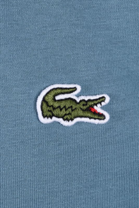 Lacoste Tee in Limestone
Experience the difference with the Lacoste Limestone Tee, a testament to Lacoste's legacy of sportswear excellence since 1933. Crafted from premium Peruvian Pima cotton, this essential tee offers superior comfort and durability. The exceptionally fine, lightweight fabric boasts a subtle sheen and a robust construction, making it a wardrobe staple you can rely on.
 
Features

Premium Pima Cotton: Experience the luxurious feel of 100% Peruvian Pima cotton, known for its superior softness and durability.
Lightweight Fabric: The 130 GSM fabric provides breathability and comfort for all-day wear.
Classic Fit: A regular, straight cut offers a timeless silhouette that looks great on everyone.  Please note: If you are between sizes, we recommend ordering one size up for a more comfortable fit.   
Iconic Branding: The embroidered crocodile on the chest adds a touch of signature Lacoste style.   
Versatile Style
Style code: TH7318