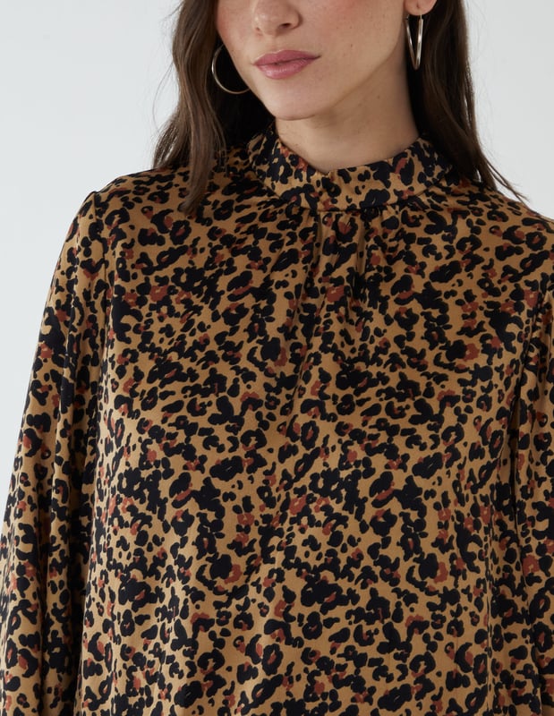 A truly classy blouson top, with puff long sleeves and a high neck to keep things simple yet professional. A perfect top to wear at your workplace, style with black trousers and high heel shoes.