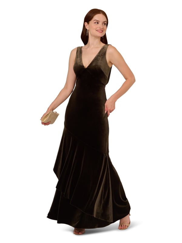 Elegant details elevate this velvet mermaid gown for the season. This formal dress features a sleeveless bodice, v-neckline, is fitted through the body, and contrasted by a mermaid skirt with a ruffled hem. Designed with a soft yet shining velvet fabric, this mermaid gown is elevated by a cowl back with a zipper closure at the centre back. Styled with nude high heels and a beaded clutch, this sleeveless velvet gown