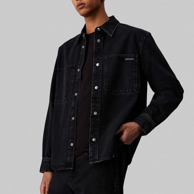 Mens Calvin Klein Regular-Fit Linear Denim Shirt in denim.- Pointed collar.- Branded metal snap buttons.- Patch chest pockets.- Barrel cuffs  curved hem.- Calvin Klein logo patch on the chest pocket.- Mid-weight cotton denim.- Regular fit.- Ref: J30J3268351BY