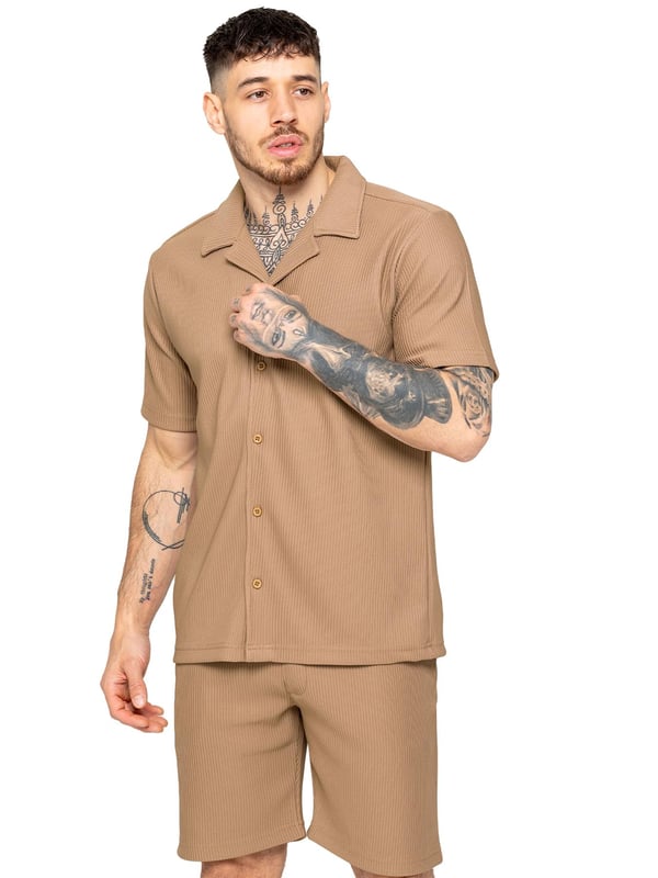Elevate your summer style with our Enzo Milano Men's Outfit Set, including a textured ribbed revere shirt and relaxed fit shorts. Experience ultimate comfort with a button fastening and adjustable drawstring waistband, while looking effortlessly stylish with a revere collar and single back welt pocket. Made with premium fabric, this set is perfect for any occasion.