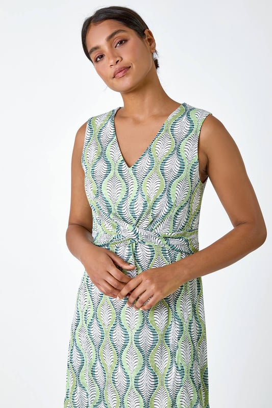 Twist Front Leaf Print Stretch Dress from Roman. Add a touch of nature to your Spring wardrobe with this stunning twist front dress. The abstract leaf print creates a fresh and playful feel, perfect for the season. The sleeveless design and v-neckline offer a feminine touch, while the knot detail at the waist flatters your figure. With its frill hem, stretch jersey fabric and burnout border print, it ensures all-day comfort and a flattering fit. Pair this midi dress with a casual denim jacket for an effortlessly chic day ensemble.