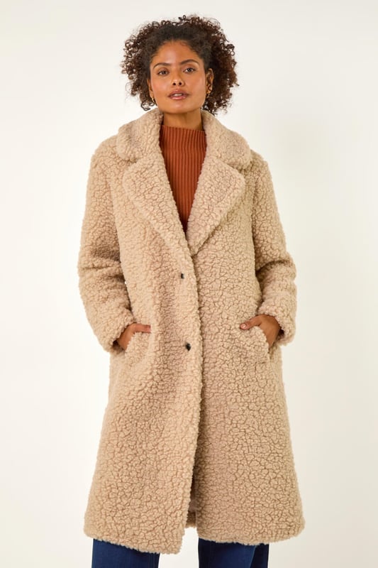 Dusk Borg Detail Longline Coat from Roman. Wrap up in style this Winter with this full-length Borg coat in classic biege. The soft Borg fabric provides ultimate warmth while the button detailing adds a touch of sophistication. Perfect for chilly days, this coat is ideal for layering over your favourite knitwear and jeans for a chic and cosy look that will keep you stylishly warm all season long!
