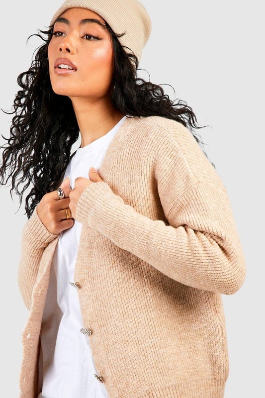 Soft knit texture for ultimate comfort
        Slouchy, relaxed fit for effortless style
        Eye-catching rhinestone buttons add a touch of glamour
        Versatile open-front design for easy layering
        Ribbed cuffs and hem for a polished finish
    
    Embrace laid-back luxury with this slouchy cardigan, perfect for the fashion-forward woman who values both style and comfort. The soft knit fabric drapes beautifully, creating a relaxed silhouette that's ideal for casual outings or cosy nights in. The standout feature is undoubtedly the sparkling rhinestone buttons, which add a subtle touch of glamour to this otherwise understated piece. Style it over a simple white tee and wide-leg trousers for a chic daytime look, or throw it on over a slip dress for an evening ensemble with a twist. For a trendy finish, pair with a beanie and chunky trainers as seen on our model. This cardigan is a versatile staple that will quickly become your go-to for family gatherings, coffee dates, or lazy weekends at home.