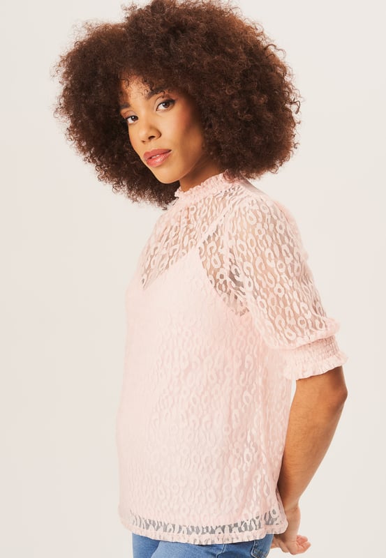 Eleva tu estilo con nuestra blusa holgada de encaje y cuello alto negra. Este elegante top combina un moderno cuello alto y delicados detalles de encaje para un look vanguardista. El corte holgado permite un uso cómodo y sin esfuerzo, lo que lo convierte en una prenda imprescindible para cualquier armario elegante.