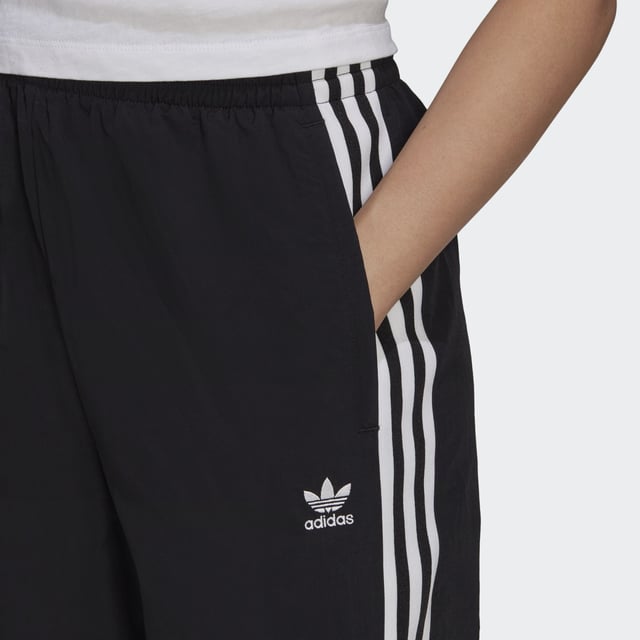 No reason is too small to treat yourself. In fact, you don't even need a reason. And with these adidas track pants in your closet, you can treat yourself any minute of the day. They're all about comfort, which is exactly what you'll feel when you slip them on. This product is made with Primegreen, a series of high-performance recycled materials.  - Regular fit - Drawcord on elastic waist - 100% recycled nylon plain weave - Side zip pockets - Elastic cuffs - Primegreen  Shipped by adidas