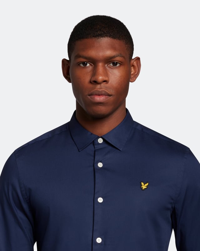 Perfect for both formal and casual occasions alike, the Lyle & Scott Slim Fit Poplin Shirt is a year-round essential. The perfect way to introduce gentle colours and tailored fits into your wardrobe, this shirt can be paired with jeans and chinos or layered with a tee. Made from a soft but mobile cotton-elastane blend and complete with smart collar, cotton cuffs, detail stitching, and signature Golden Eagle.Fit: Slim
Designed to give you a tailored fit that more closely follows the lines of the body than our regular cut clothing. If you're caught between two sizes, we recommend you purchase the larger size.