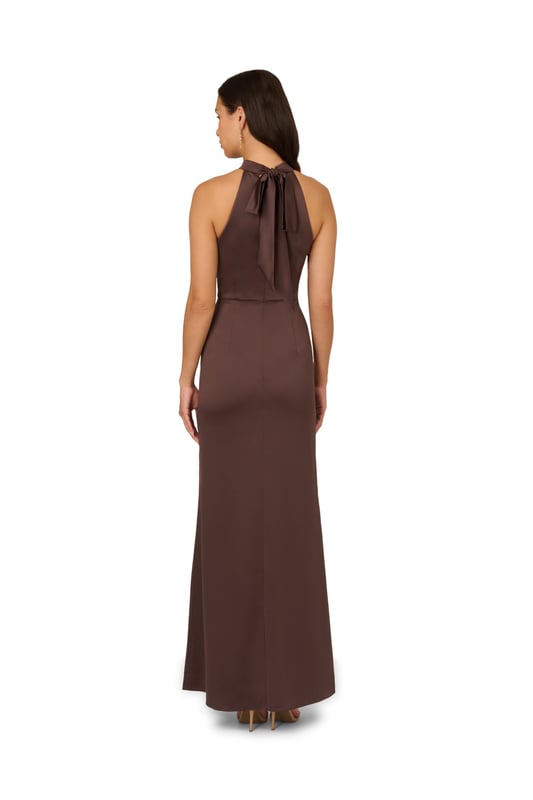 Fall for dreamy fabric and details when you select this satin mermaid gown for your next occasion. This formal dress features a sleeveless halter bodice, mock neckline, and a mermaid skirt with a slit trimmed with ruffles. Designed with satin fabric, the bodice of this formal dress has princess seams for a fit that flatters your figure. A self-tie neck adorns the cutout back and a hidden zipper closure at the centre back completes this evening gown. Paired with statement jewellery and metallic heels, this sleeveless satin gown will shine for formal and black-tie events.
