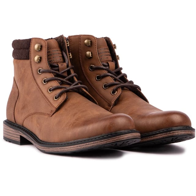 El botín Bala de Soletrader es un botín Chukka práctico y elegante de estilo campestre para el uso diario. Elaborado a partir de un material duradero. Parte superior color canela con adornos de tela hasta el tobillo para mayor comodidad. Estas botas para hombre cuentan con ojales de metal y ganchos estilo excursionista en la parte superior para una apariencia discreta junto con una suela con tacos para un mejor agarre cuando se sale de casa en los cambios de estación.