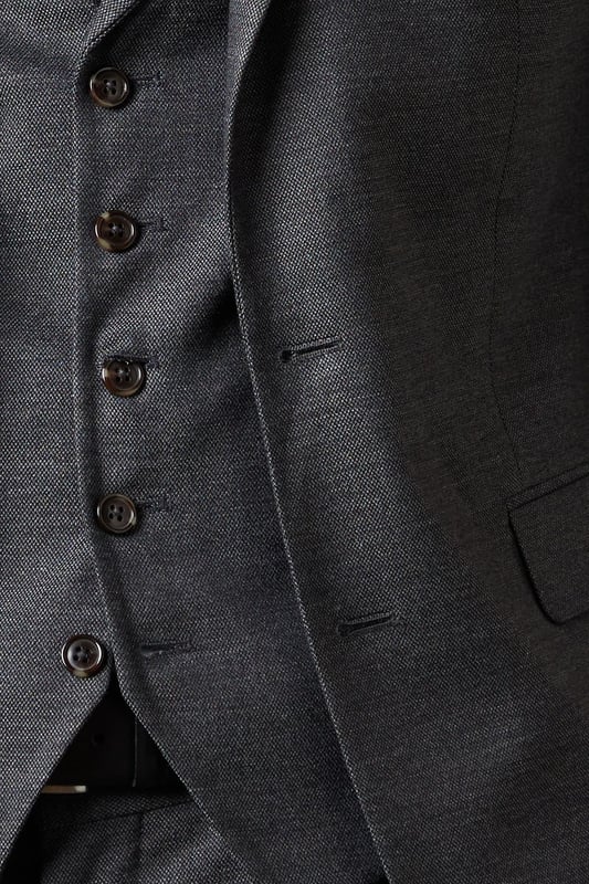 Slim fit design for a modern, tailored silhouette
        Tweed-look fabric adds texture and sophistication
        Notched lapels and two-button closure for classic styling
        Flap pockets and chest welt pocket for practicality and style
        Versatile charcoal hue suitable for various occasions
    
    This Burton slim fit suit jacket presents a refined option for the discerning gentleman. The tweed-look fabric lends a touch of traditional charm to a contemporary silhouette, making it an ideal choice for the modern man who appreciates classic style. Perfect for smart casual events or more formal occasions, this jacket can be styled with matching trousers and a waistcoat for a complete suited look. For a sophisticated ensemble, pair with a crisp white shirt and a deep burgundy tie as shown. Alternatively, dress it down with a light blue Oxford shirt and dark denim for a smart pub outing with mates. The versatile charcoal hue ensures this jacket will become a staple in your wardrobe, easily transitioning from office to evening wear. Whether you're heading to a business meeting or a weekend wedding, this Burton suit jacket will have you looking sharp and feeling confident.
