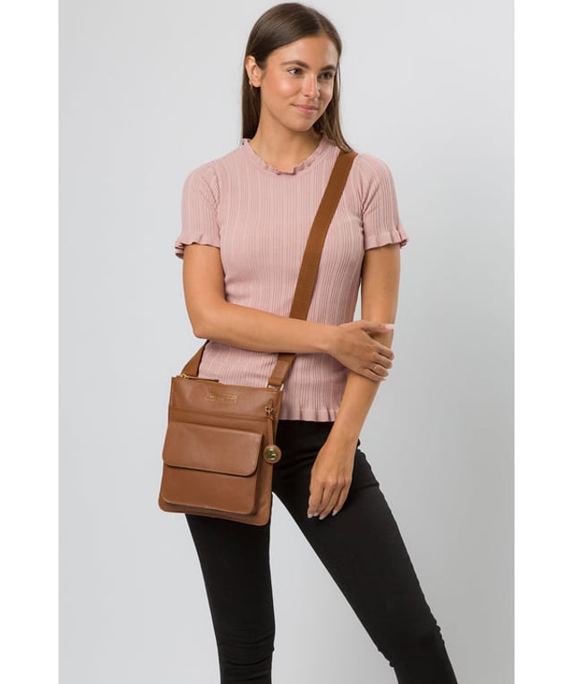 Crafted from supple leather, the 'Langley' cross body bag from Pure Luxuries London elevates a classic design with a luxury finish. A zip-over top fastening conceals the 100% natural cotton lined interior and is complemented by two slip pockets, ideal for maintaining an organised bag. Additional storage space is provided by a slip pocket and a press-stud fastened pocket. Adorned with an adjustable strap and finished with a beautiful Pure Luxuries London charm and logo for an elegant finish.