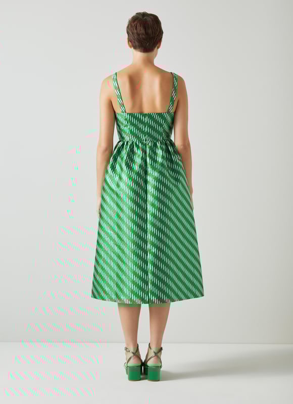 A dress that says 'belle of the ball', Elodie is a beautiful reimagition of our hero Olsen skirt, but in dress form. Crafted from voluminous, bouncy fabric with a green, black, white and metallic geometric weave, Elodie has a square neckline, slim shoulder straps, a gathered waist, side pockets and a puffy shape falling to just below the knee. Wear with green satin platforms to perfectly match, or style more casually with simple ballet flats - she's versatile, and very good fun.