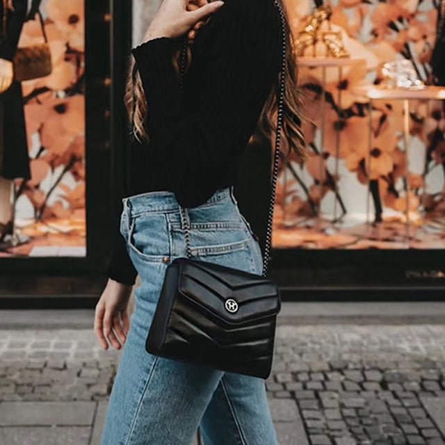 The New English Lady Bag in black is an absolute must-have. The classic black handbag can be combined in many ways and is the ideal companion for all situations in life. This bag from Victoria Hyde London also convinces with its high quality - made of genuine leather. In addition, it impresses with minimalist details - a golden logo plate, a quilted pattern in the leather and a black metal strap decorate the bag. The handbag can be worn over the shoulder as well as a crossbody bag.

Dimensions: 18.5cm x 14.5cm x 7cm
Carrying strap length: 95cm
Carrying strap height: 47cm
Texture: genuine leather