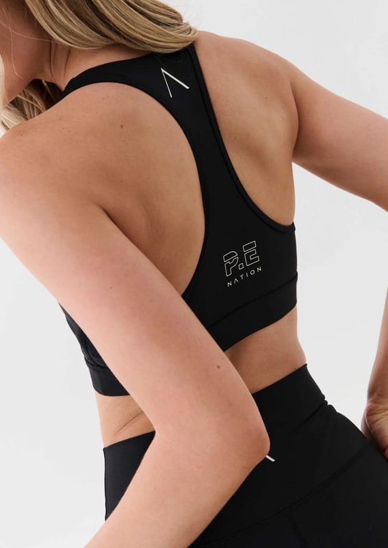 Scoop neck sports bra with a racer style back. Built in elasticated underbust support. KAAIAA logo print at front and back. P.E Nation logo print at back