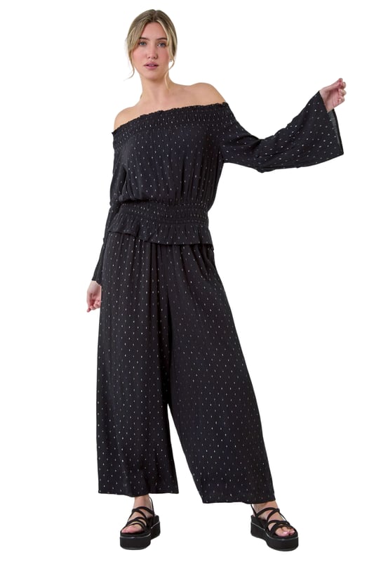 Shimmer Foil Textured Bardot Top from Roman. Shimmer into the new season with this metallic foil print bardot top. With its off-the-shoulder neckline and tiered sleeves, it exudes effortless Summer elegance. Made from a crinkle woven fabric, this top will keep you cool and comfortable on warm days with its relaxed bardot finish. The shirred stretch neck and waist provide a flattering fit, while the frill hem adds a feminine touch. Pair it with matching wide leg trousers (18061508) from our Dusk Collection for a chic and coordinated look or with denim jeans for casual Spring looks.