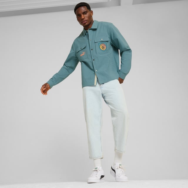 PRODUCT STORY: Marking 30 years of Definitely Maybe, its Definitely City. Co-designed by Noel Gallagher, a lifelong Man City fan, this relaxed fit overshirt pays homage to an album that defined an era. FEATURES & BENEFITS: Made with at least 20% recycled cotton. DETAILS: Relaxed fit; 165gsm, seersucker; Collar; Button placket; Long sleeves; Official team branding details. Our model is 186 cm tall and is wearing size M UK.