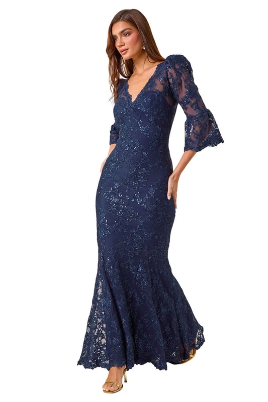 Lace Scallop V-Neck Bodycon Maxi Dress from Roman. Feel elegant and sophisticated in our stunning lace bodycon maxi dress, perfect for the Autumn Winter season. The feminine v-neckline is adorned with delicate scalloped lace details for a touch of romance. Designed in a flattering bodycon shape, this dress is crafted and lined from a comfortable woven fabric, finishing at maxi length with long sleeves to keep you warm at your next special occasion. Style with heels and a bolero for a truly unforgettable outfit!