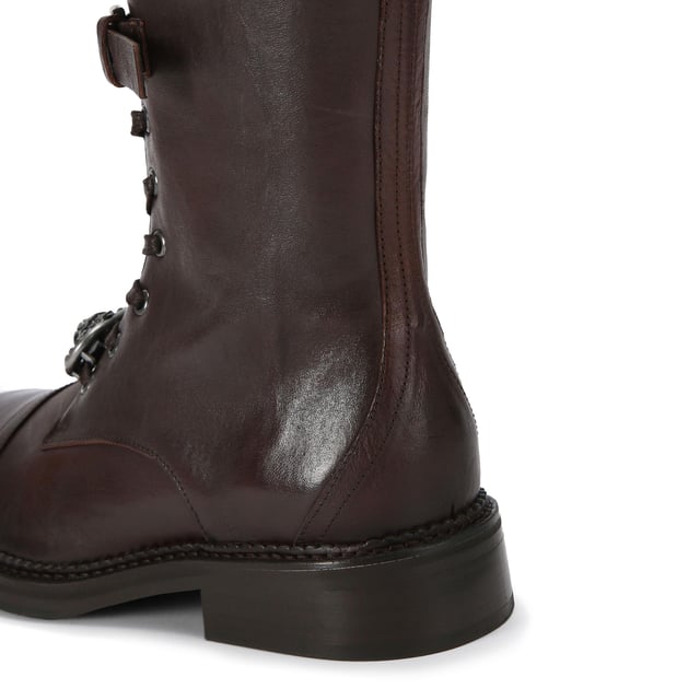 This Kurt Geiger Monument Strap Boot is crafted from a brown leather. There are three buckled straps across the front of the boot and a lace up detail at the bottom. There is a statement antiqued silver oval trim with eagle head at the centre with all over crystal detail attached to the laces.