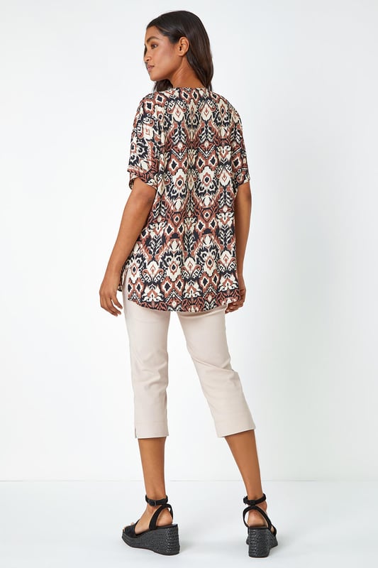 Button Detail Aztec Print Top from Roman. Step into the Summer with neutral prints and relaxed silhouettes. This overshirt has a bold statement button at the front, a feminine v-neckline and short batwing sleeves. It’s designed from a loose woven material for a comfortable and breezy everyday fit. Pair this ikat printed tee with a pair of cropped trousers and wedges for a stylish casual Spring Summer look.