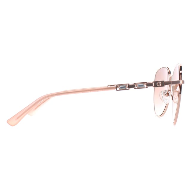 Guess Aviator Womens Shiny Rose Gold Brown Gradient GF6143  Sunglasses are a glamorous aviator frame, exuding a sense of timeless elegance. The frame is crafted from high-quality metal, known for its durability and lightweight feel, ensuring long-lasting comfort throughout the day. The slender temples feature the Guess logo for authenticity.