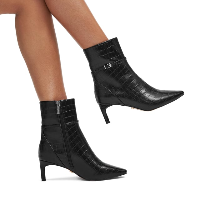 This Carvela Impress Ankle Boot features a black croc embossed upper. There is a thin ankle strap around the ankle with gold tone buckle. Heel height: 6cm.