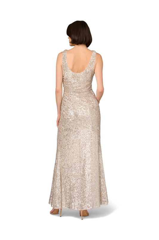Add glamor to your next night out with this sequin gown. This formal dress features a sleeveless bodice, cowl neckline, and a mermaid skirt with a side slit. Made from stretch sequin fabric, this gown is fully lined and ultra comfortable. Gathered details at the sides creates a beautiful, shirred effect, which flatters the figure. A side zipper closure completes this evening gown. Style this sequin dress with nude heels and a satin clutch for a look that will belong in any room you walk into.