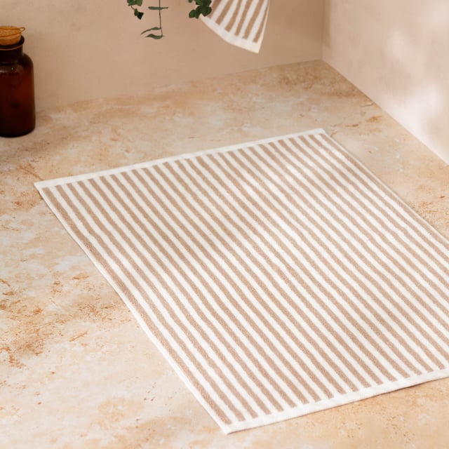Elevate your bathroom with the Hebden Striped Cotton Bath Mat, crafted from 100% cotton terry for an irresistibly soft feel underfoot. Combining a timeless striped design with versatile contemporary shades, it brings a perfect balance of classic and modern style to your space. Designed to create a cool, calming atmosphere, this bath mat promises more than just style—it enhances your sense of comfort and wellbeing. Durable and naturally breathable, it offers practicality to match its beauty, making it an essential finishing touch to your home environment.
