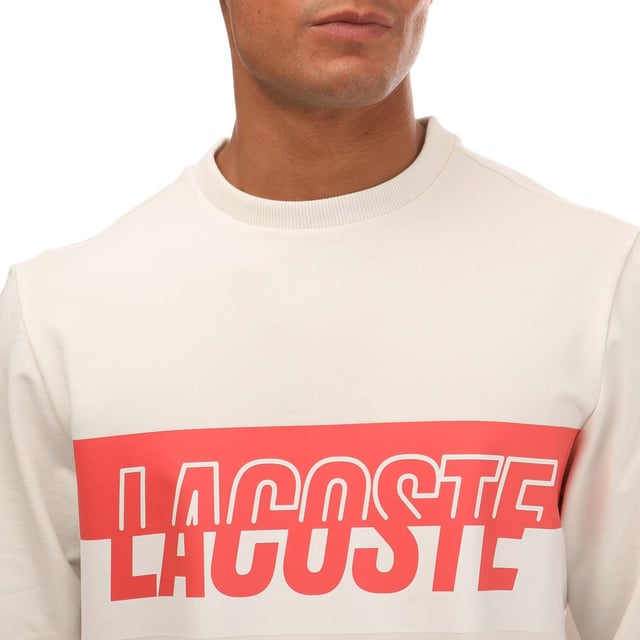 Bold. Colorful. Audacious. A new generation of Active wardrobe. This new style  dedicated to GenZ  have a bold and eye-catching Lacoste print in the middle. Break traditional codes and create a new strong identity with a playful mash up of colors. This sweatshirt is a fashion must-have. Loungewear sweatshirt Regular fit: natural ease on body Lightweight French terry Crew neck Ribbed cuffs and body bottom Bicolor cut and shifted Lacoste branding on chest 