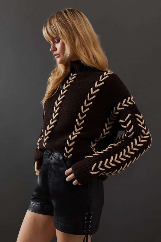 Oversized fit for a relaxed, contemporary silhouette
        Striking whipstitch detail in a contrasting hue
        Long sleeves with dropped shoulders for added comfort
        High neck design for extra warmth and style
        Versatile piece suitable for various casual occasions
    
    This Warehouse jumper radiates confidence with its bold whipstitch detailing and oversized fit. The contrasting stitching creates an eye-catching pattern that runs vertically down the garment, adding visual interest and texture. Perfect for those who appreciate edgy yet feminine style, this jumper can be effortlessly styled for various casual events. Pair it with leather shorts and ankle boots for a night out with friends, or throw it over your favourite jeans for a cosy family gathering. The high neck and long sleeves offer warmth without compromising on style, making it an ideal choice for transitional weather. For a more relaxed look, team it with wide-leg trousers and trainers. This versatile piece allows you to express your unique style while maintaining comfort, embodying the essence of contemporary British fashion.