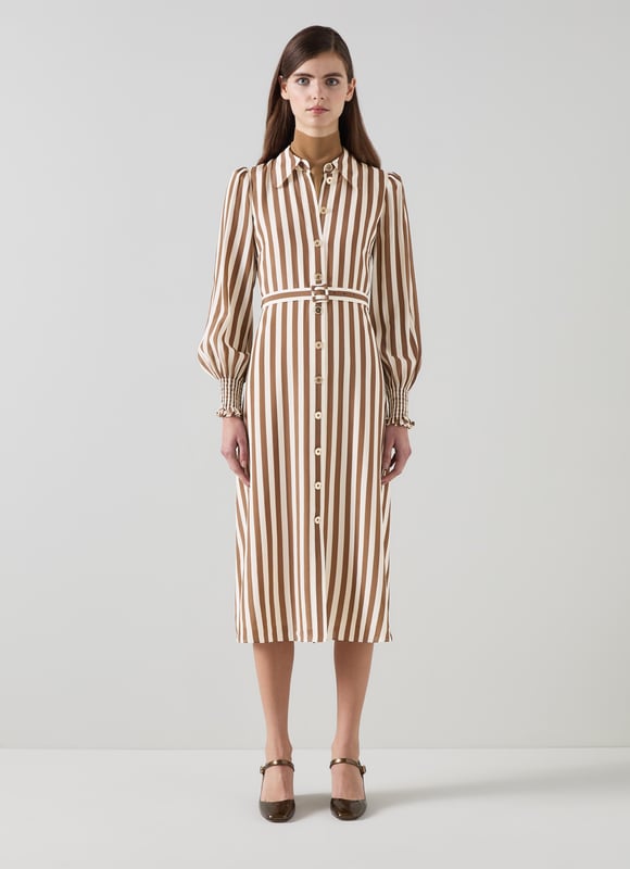 Imagine a breezy afternoon stroll wearing the Emelia candy stripe shirt dress in chocolate and birch. This stylish piece in chocolate and birch silk boasts a classic collar, full length sleeves, and a sophisticated woven stripe design, perfect for smart casual outings. Pair it with elegant flats for a daytime look or enhance it with heels for an evening out.