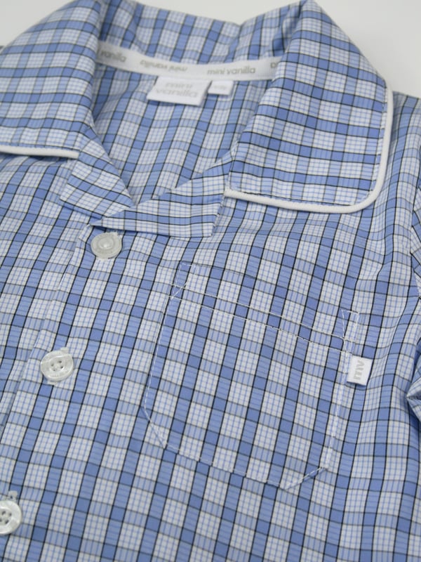 Boys mini check PJ set in shades of mid blue. Spring & Summer weight 100% Cotton with short sleeves
Classic traditional styling, engraved pearl effect buttons and contrast piping. With an elastic waist, making them easy to get on and off 
100% Cotton
Elastic waist
Front pocket
Button through top
Machine washable
Contrast piping detail