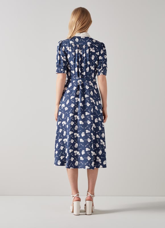A beautiful spring dress in a super-fun and kitsch pop-art print, our Valerie shirt dress is a great everyday style. Crafted from silky fabric in a navy and cream 1960's lock and heart print reimagined from vintage archives, it has a Seventies-inspired contrast collar, puff shoulders, short sleeves, cream buttons, a buckle belt and a midi-length skirt. Wear it with a pair of platform heels for spring occasions.