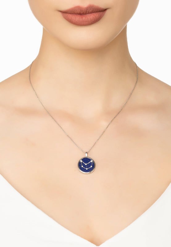 Looking for a neck piece that is out of this world? Look no further than our Zodiac Lapis Lazuli Gemstone Star Constellation Pendant Necklace Silver! The natural beauty of dark blue lapis lazuli, as wondrous as the sky at night, makes the perfect backdrop to the twinkling constellation on each pendant. Engraved with your star sign name and detailed with cut-out stars on the reverse, this pendant is sure to add a touch of starlit elegance wherever you go.Capricorns celebrate birthdays December 22 - January 19, they are hard-working, grounded and loyal individuals. They are focused on achieving their goals and are not afraid to put in a lot of effort to achieve success.Crafted from 925 sterling silver encasing a disc of Lapis lazuli, it’s a beautiful way to express your personality in fashionable form. With a diameter of 2 cm, a length of 40 cm plus 5 cm adjuster, to wear long or short and a weight of 5.3 grams, you can make this jewellery your own and create the perfect accessory for that special occasion or everyday look.So go explore the universe with our beautiful Zodiac Lapis Lazuli Gemstone Star Constellation Pendant Necklace.