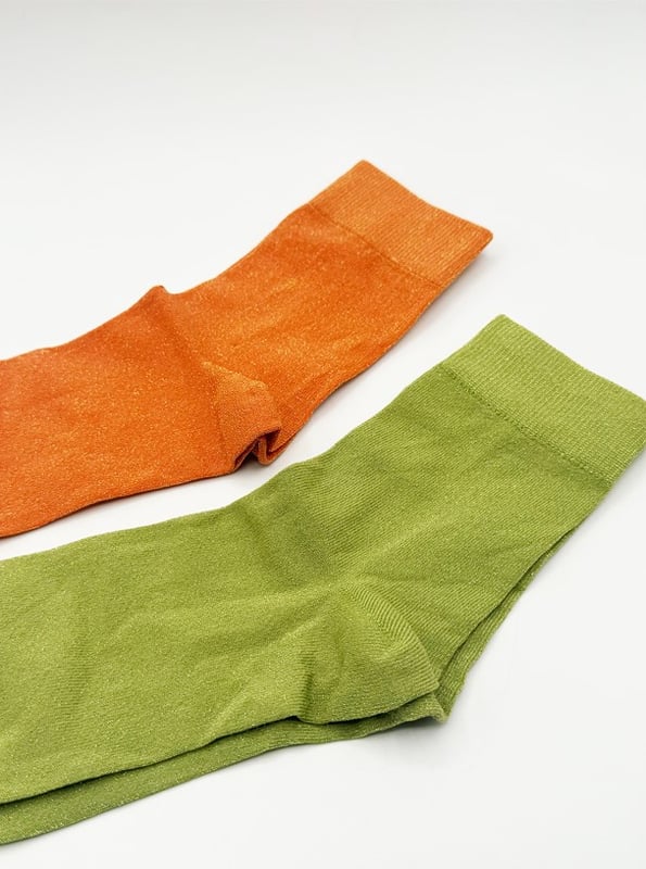 Get into the spirit of the season with this fun and vibrant glitter sock set by SVNX. Featuring two pairs in bold orange and green, they're perfect for adding a pop of sparkle to any outfit. Treat yourself or surprise someone special with a gift that combines style and festive flair! Knitted Glitter Socks Set. One size. 2 pairs. Gift Box. Cotton/Polyamide/Elastane. Wash at 40. Made in China