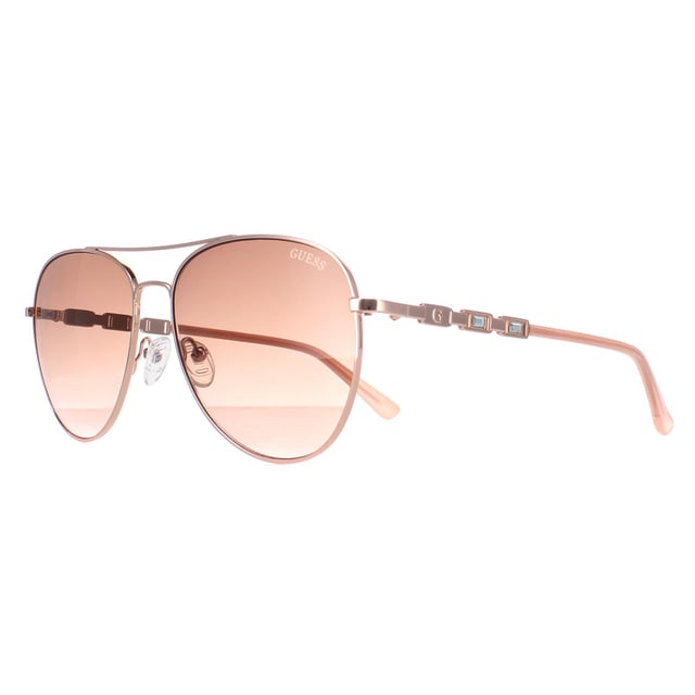 Guess Aviator Womens Shiny Rose Gold Brown Gradient GF6143  Sunglasses are a glamorous aviator frame, exuding a sense of timeless elegance. The frame is crafted from high-quality metal, known for its durability and lightweight feel, ensuring long-lasting comfort throughout the day. The slender temples feature the Guess logo for authenticity.