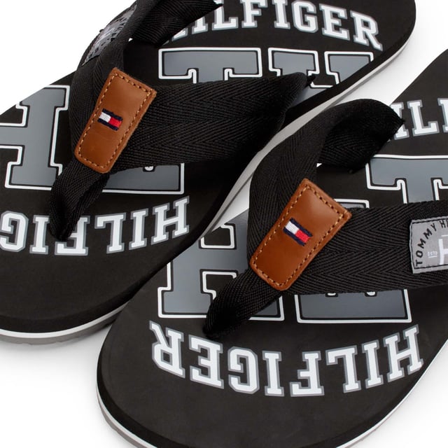 Mens Tommy Hilfiger Essential Beach Flip Flops in black.- Synthetic upper.- Slip on design.- Branded retro graphics.- Synthetic lining.- Rubber sole.- Ref.: FM0FM01369990