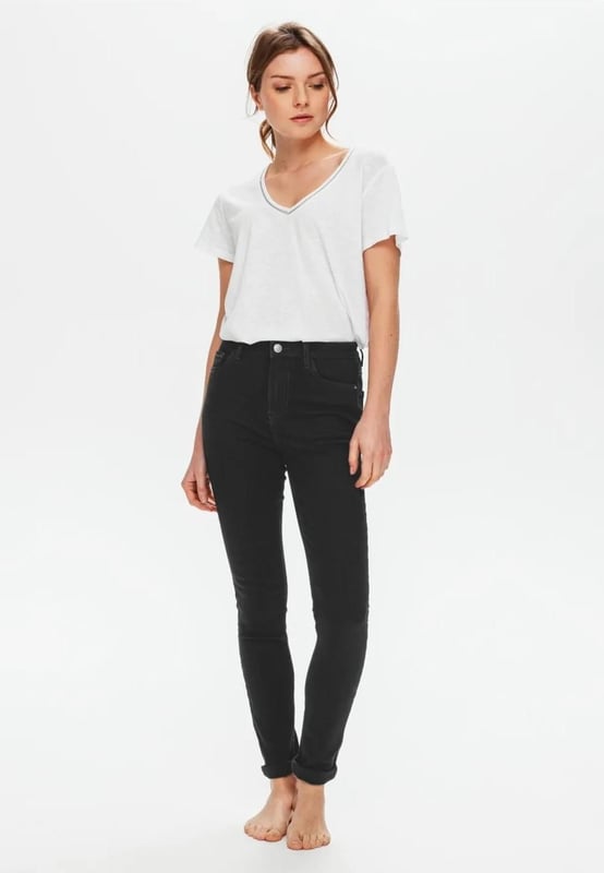Deze zwarte jeans met hoge taille heeft gerecyclede vezels. Skinny, voor een slank en leggy effect. Van zacht denim. Rekbaar. Riemlussen. Stud knoop, metalen rits. Metalen klinknagels. Een favoriet in je garderobe!