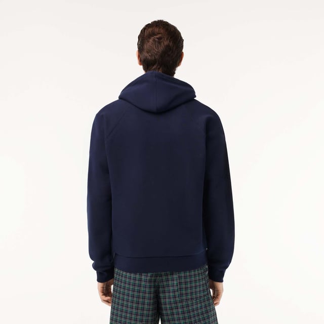Own the french fashion sport Hoodie in French Terry Raglan sleeves Kagaroo pocket Knot drawcord 55x53 cm felt badge with Lacoste Paris embroidery and green crocodile on chest.