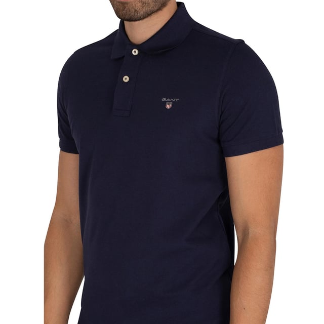 Diese Original-Herren-Designer-Polos mit kurzen Ärmeln von Gant verfügen über das Markenlogo, einen kontrastierenden Saum und einen Button-Down-Ausschnitt mit Kragen. Gefertigt aus 100% Baumwolle, sind diese leichten und atmungsaktiven Polos mit normaler Passform für Freizeit- und Arbeitskleidung geeignet.