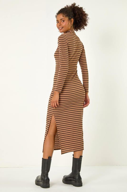 High Neck Stripe Bodycon Midi Dress from Roman. Elevate this Autumn Winter with our midi dress adorned in a timeless stripe print. Designed to finish at midi length, this dress showcases a flattering bodycon shape, complete with a high neckline and long sleeves to keep you warm throughout the colder season. Crafted from a cosy ribbed fabric, this dress is an essential to stay both stylish and comfortable. Pair it effortlessly with a denim jacket and boots for a complete fall look.