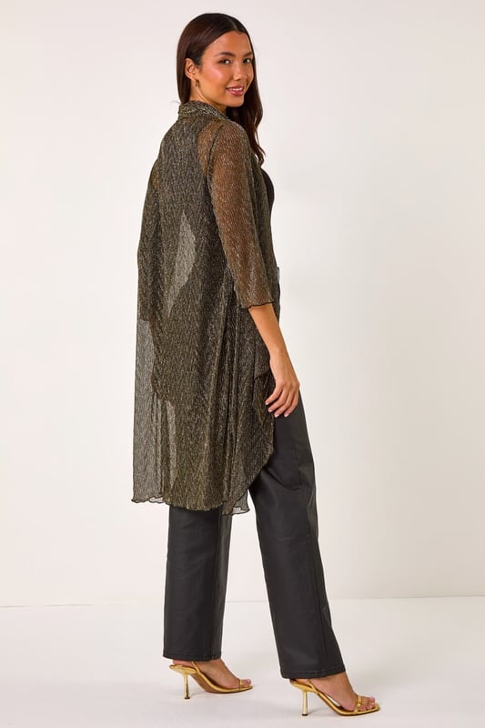 Shimmer Plisse Longline Kimono from Roman. Wrap up in style this Autumn/Winter with this gorgeous plisse longline kimono. Featuring a striking chevron metallic print and crafted from stretch plisse fabric, this kimono exudes elegance. With a flattering longline length, long sleeves, and an edge to edge design, it's perfect for layering over any outfit. The waterfall front adds a touch of sophistication. Pair it with a simple t-shirt and PU trousers for a chic and on trend look!