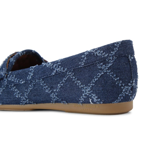 The Kurt Geiger Greenwich Moccasin slip-on loafer features a blue denim upper with frayed diamond quilting design. There is antiqued brass branding on the front alongside micro eagle head.