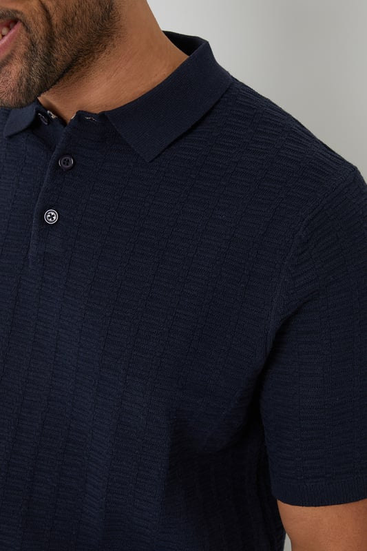 Add an easy-to-wear staple to your transitional wardrobe with this Threadbare button up knitted polo.
With an open collar fashioned with button up detail, this short sleeve knitted polo has small ribbed cuffs to the sleeve and a ribbed hem for comfort and ease.
In a textured stitch to the body to make it the perfect transitional piece for in-between weather, and finished with a metal branded tab above the hem.
Pair it with chinos or denim jeans and a smart coat for day-to-day wear that also works perfect for date night, or team with shorts for summer style.